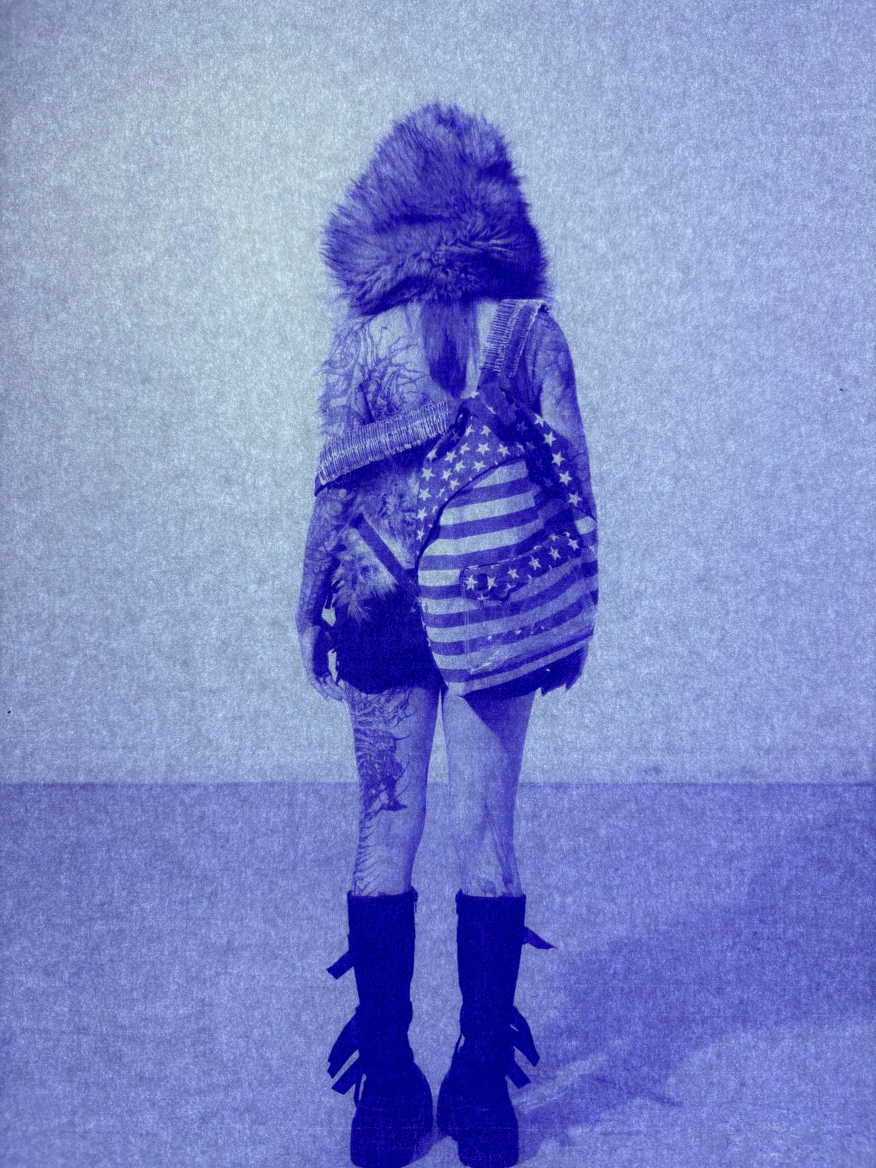 Blue-toned portrait of a tattooed model wearing the Armor Backpack — American Flag.